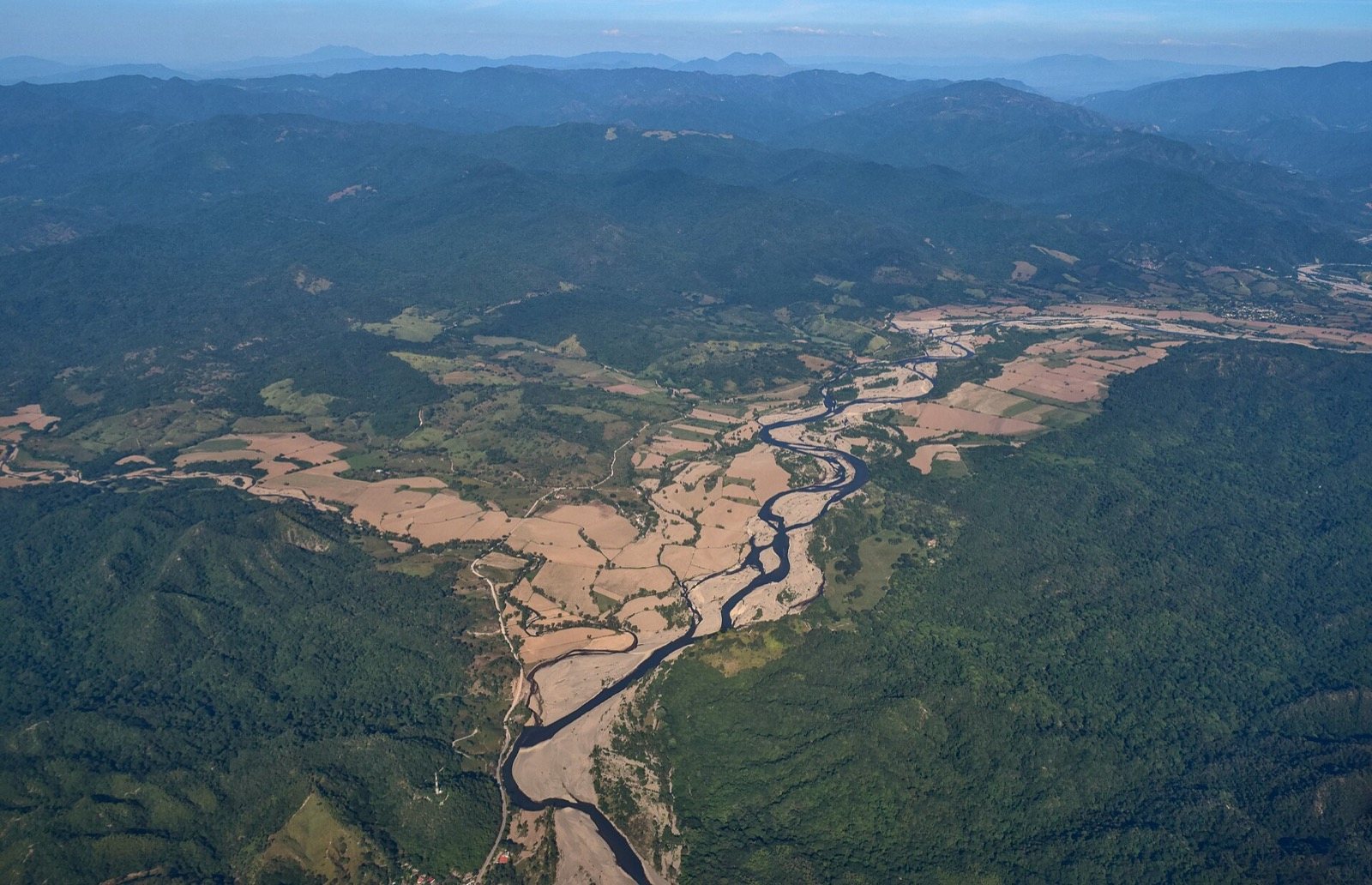 Aerial view of the Ameca River winding between farm fields and forested mountains