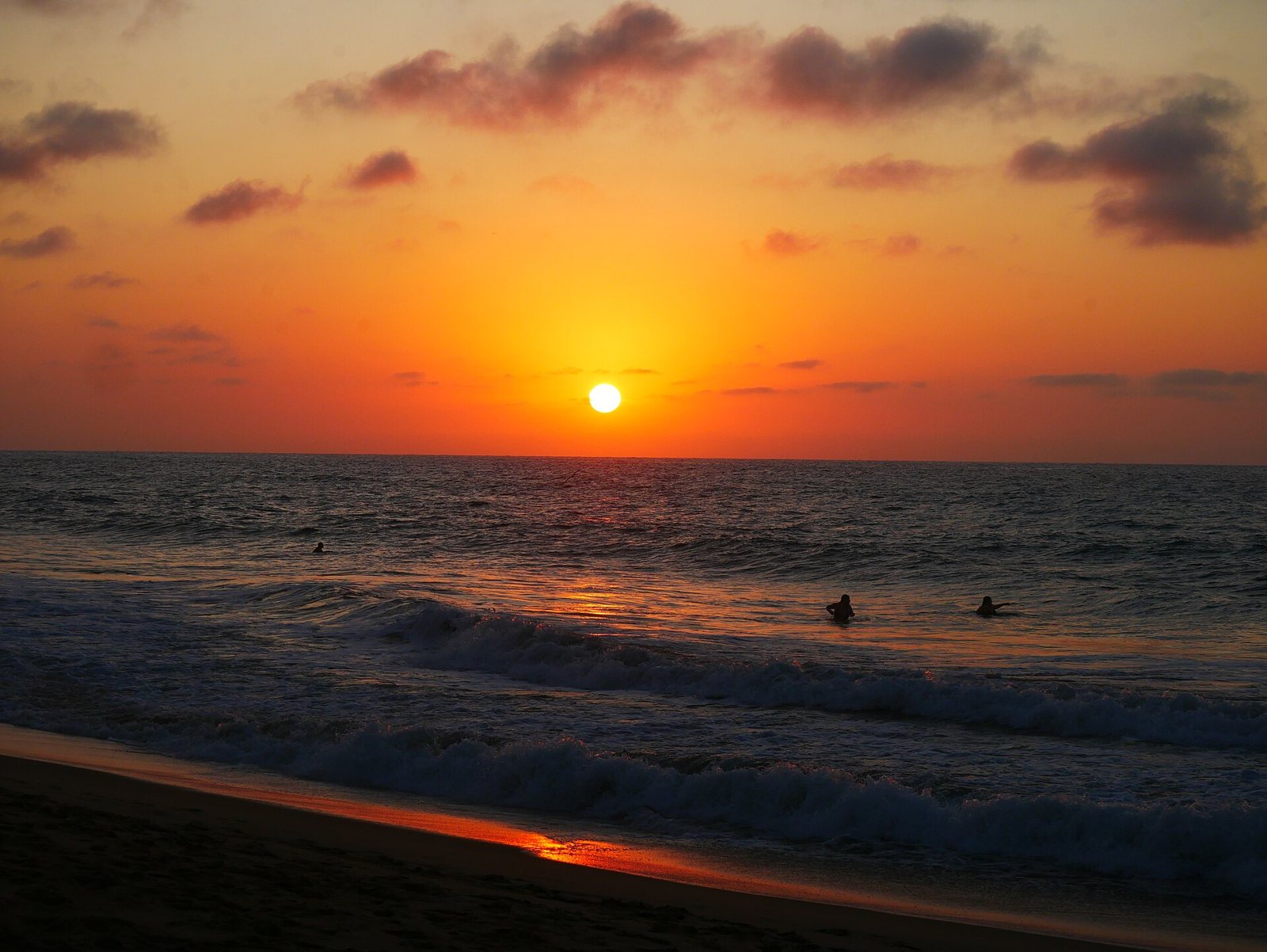 Orange sunset over the ocean at San Pancho beach, with the sun about to dip below the horizon