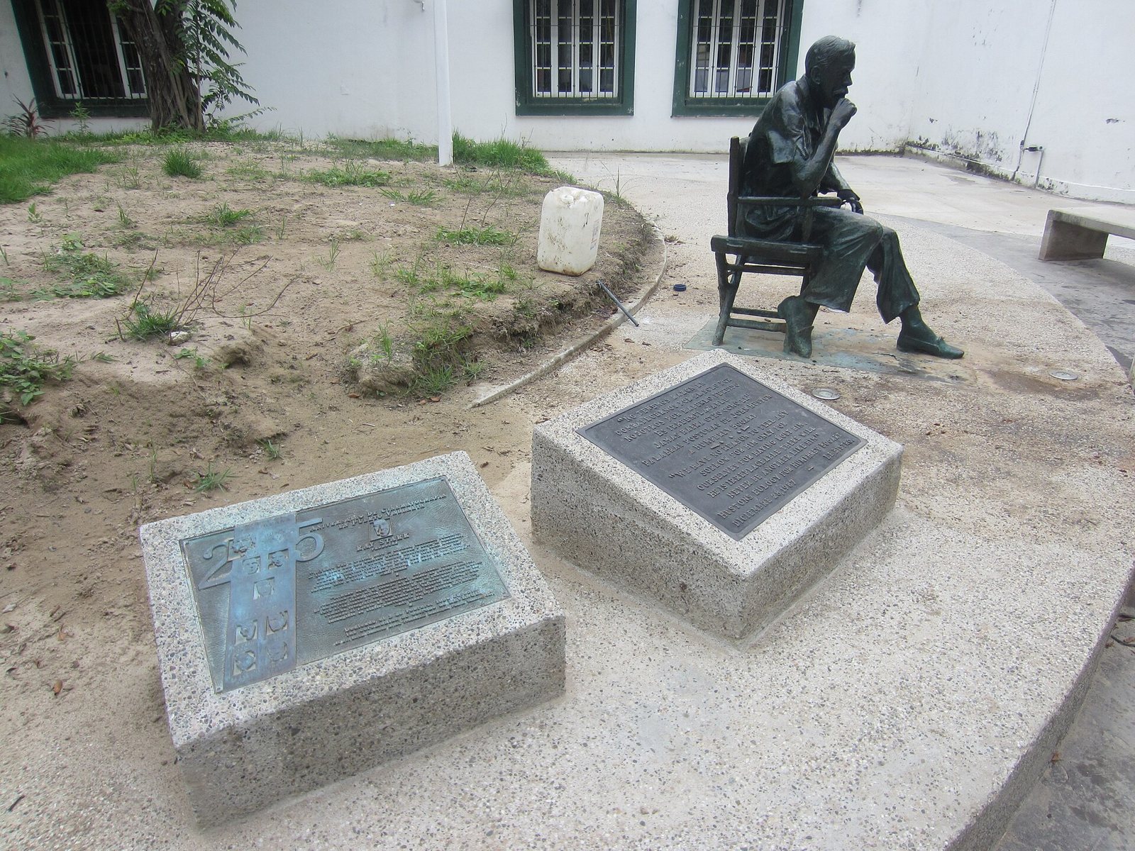 Bronze statue of John Huston seated in a director's chair next to commemorative plaques in Puerto Vallarta