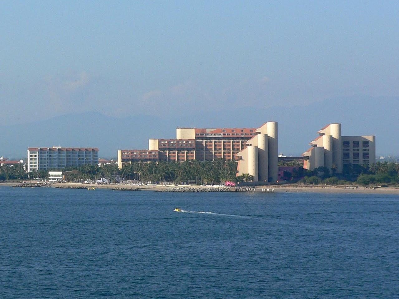 The Westin Resort & Spa Puerto Vallarta buildings seen from the sea, with curved towers, palm trees and the beach